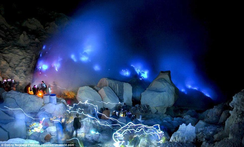 Stunning photos show a BLUE volcano lighting up the skies of Indonesia as mesmerised tourists look on