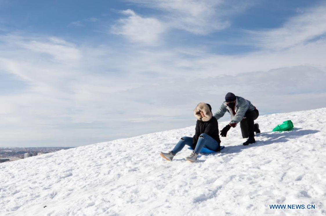 People enjoy snow in park in Madrid, Spain