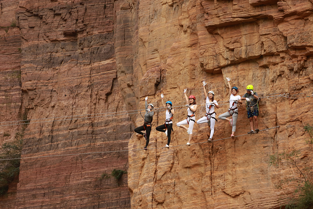 Yoga enthusiasts practice on high-altitude steel wires